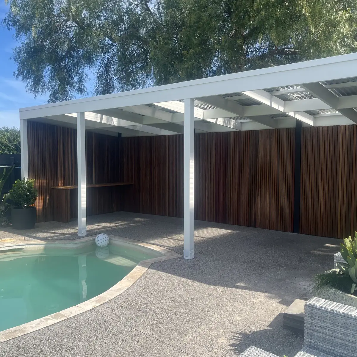 Poolside landscaping with paved surrounds and lush planting